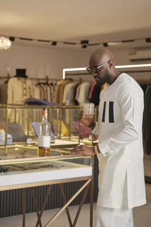 Pristine white kaftan with gold pinstripes, accented by a contrasting navy blue chest pocket.